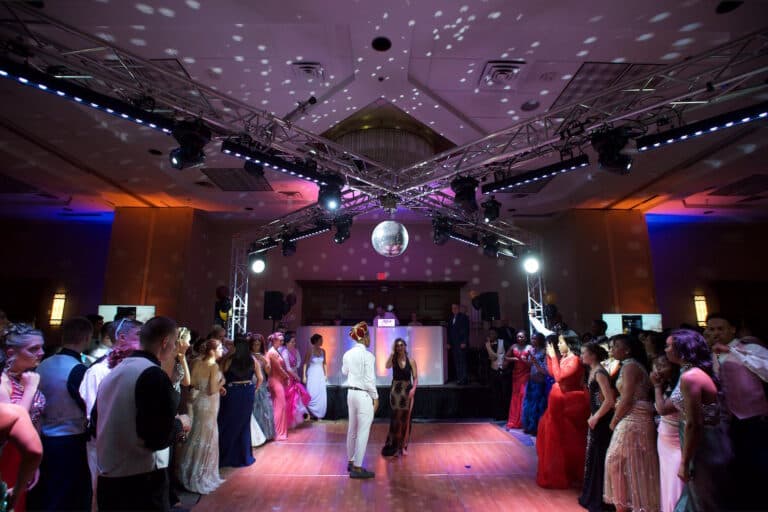 Prom guests circle the dance floor beneath the X-shaped truss rig and mirror ball