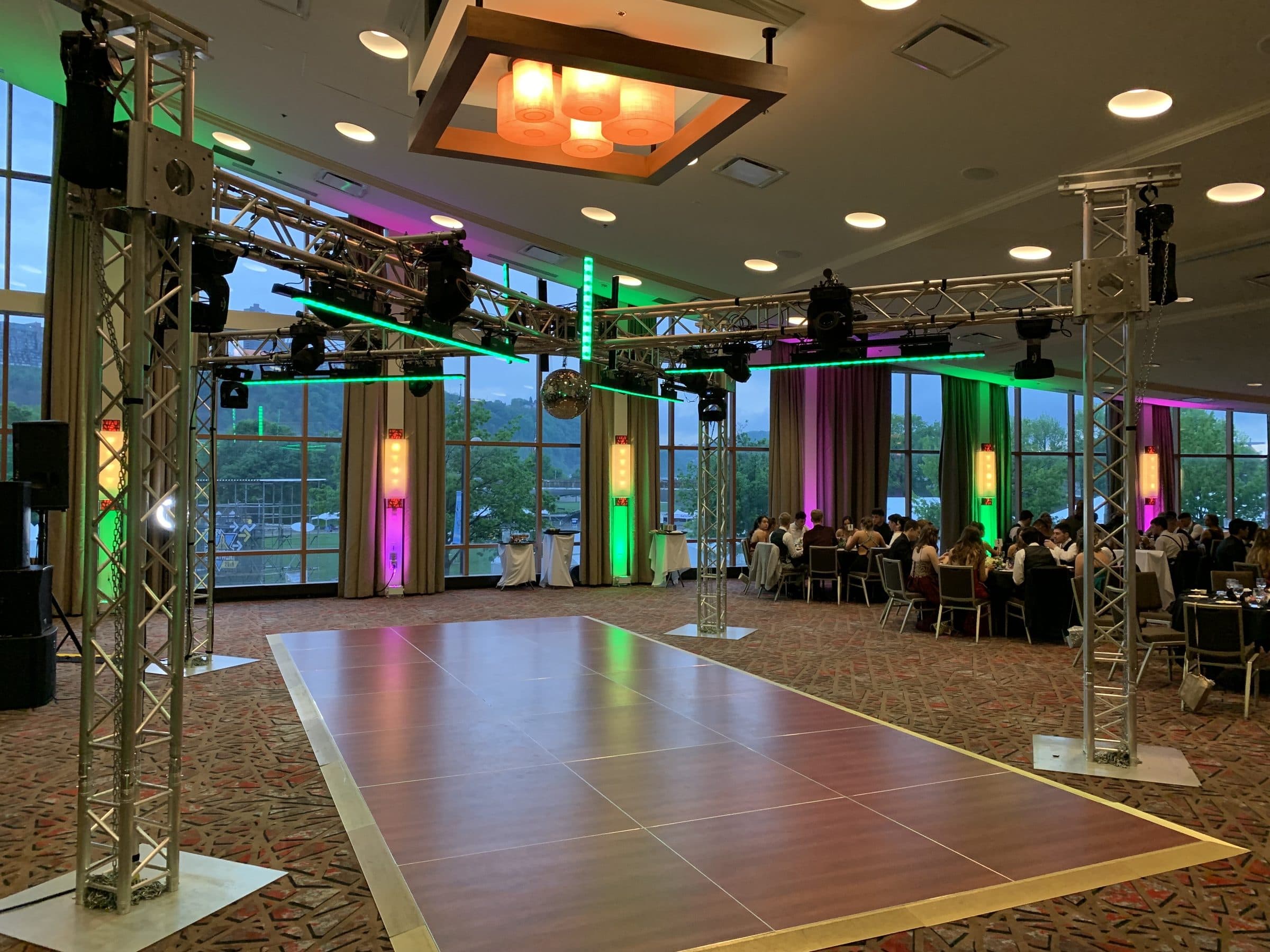 Titanium X: the X truss and mirror ball over the dance floor, riverfront ballroom windows behind
