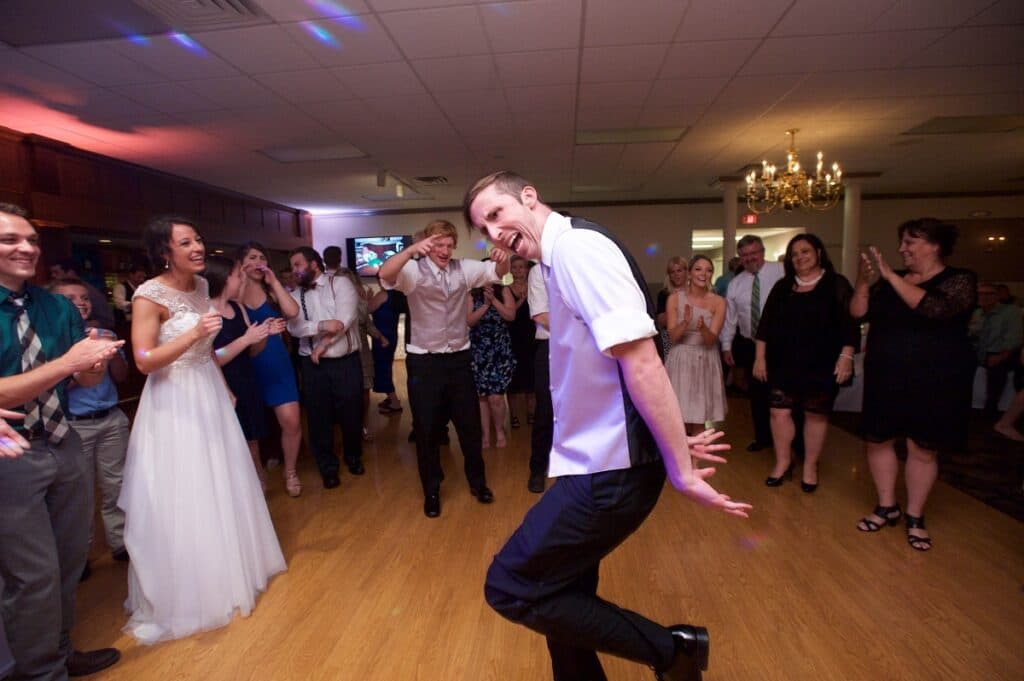 Bride laughs as the groom dances in a circle of clapping guests at a Pittsburgh wedding reception