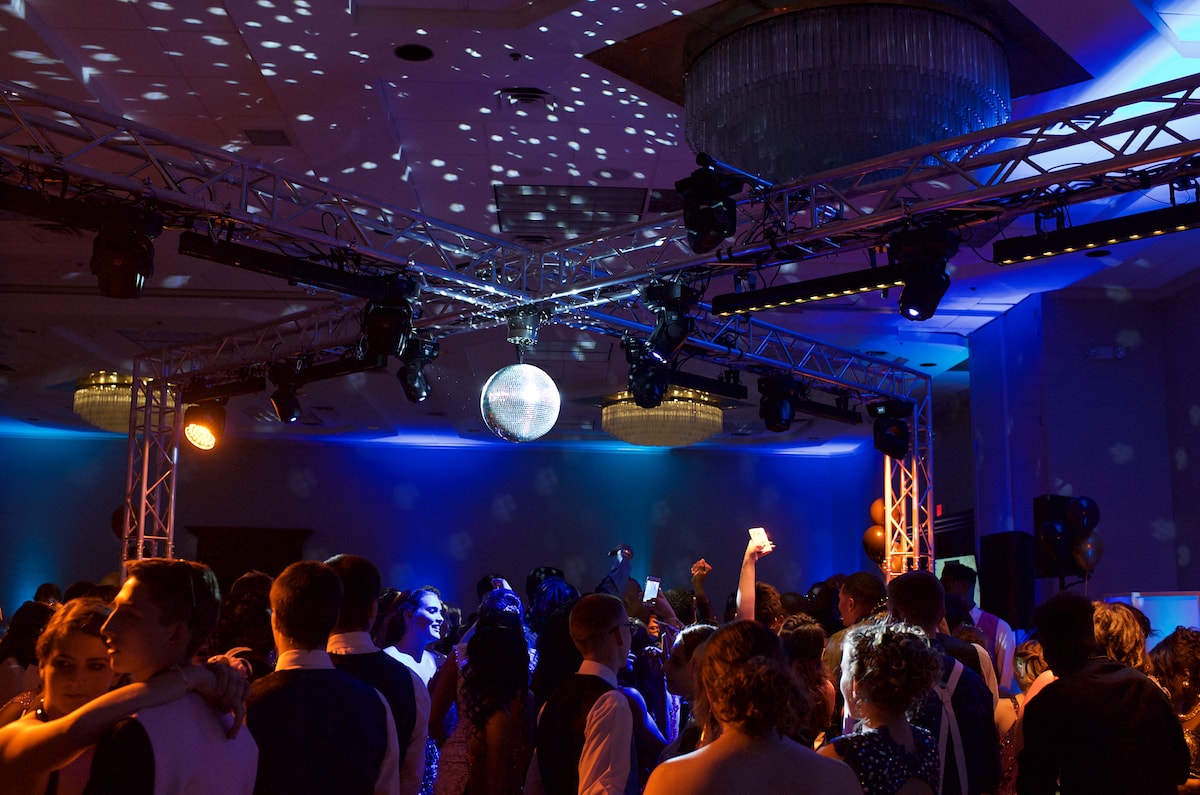 X-shaped overhead truss rig with a mirror ball and moving heads above a prom dance floor