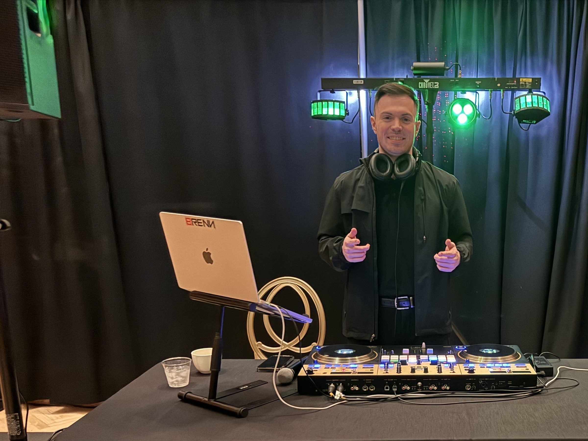 Bronze package: DJ at a controller in front of a compact lighting bar with LED effect lights on black drape