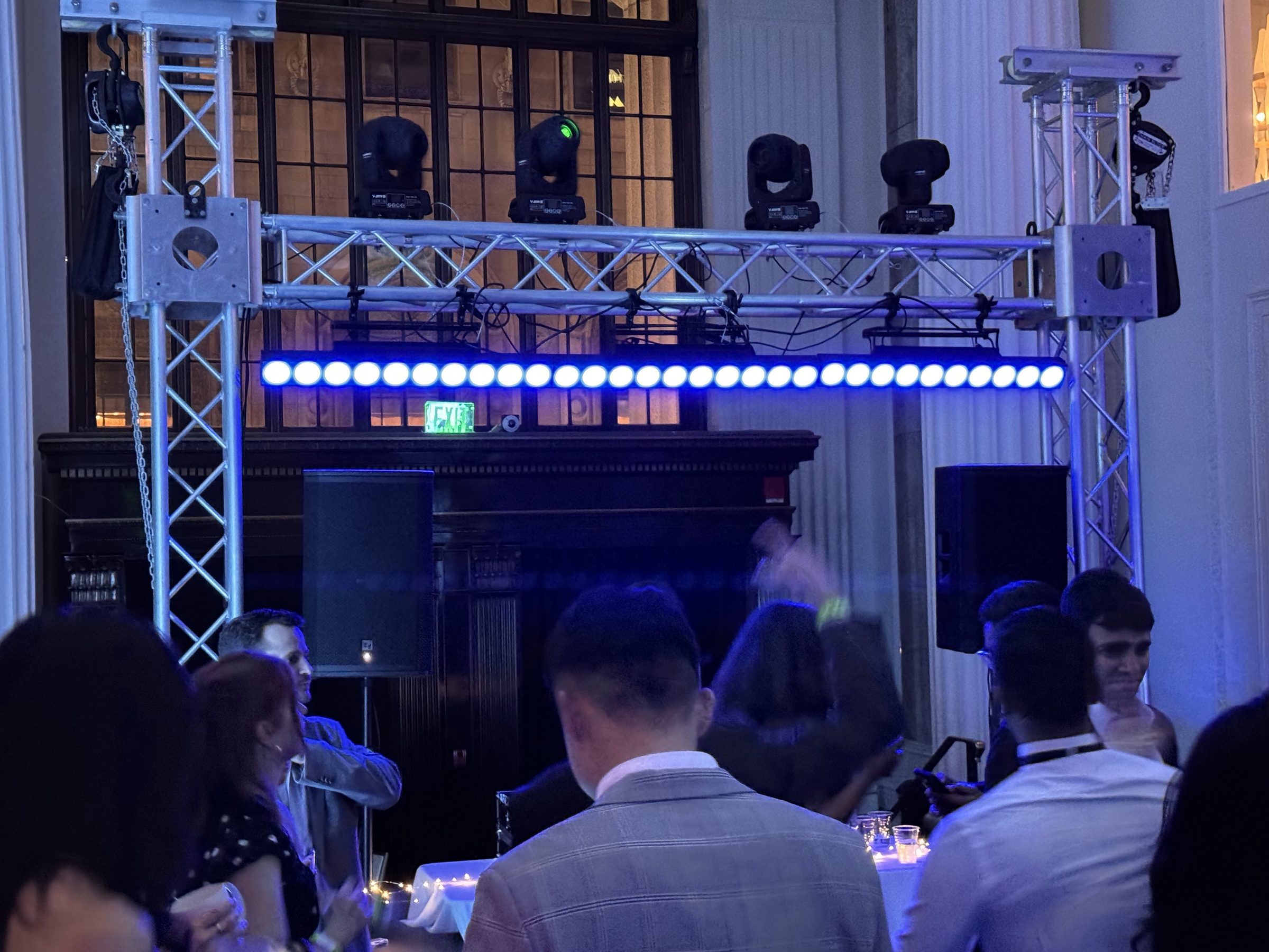 Gold package: truss goalpost with four moving heads and a long LED bar over a dance floor in a historic downtown hall