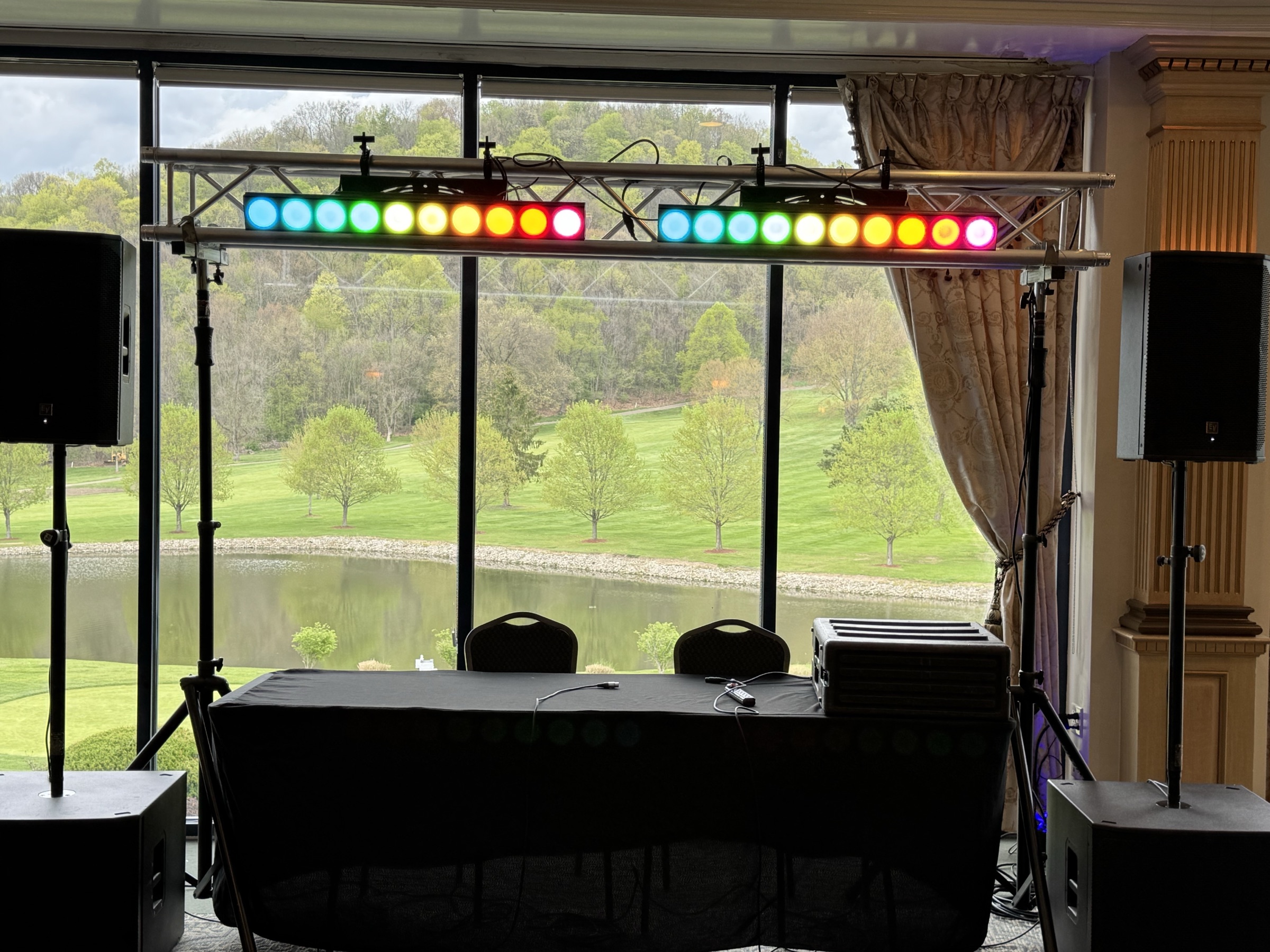 Silver package: two color LED bars on a compact truss above the DJ table, speakers on stands
